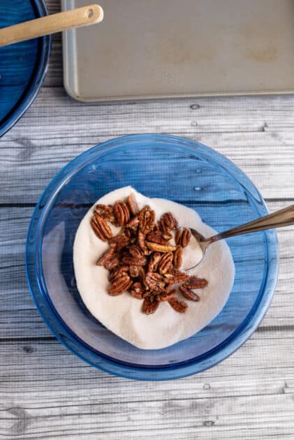 Slowly add pecans to cinnamon mixture to coat and then place them on the baking sheet.