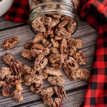 Candied pecans spilling out of a mason jar.