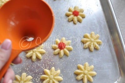 Adding decorations to spritz cookies.