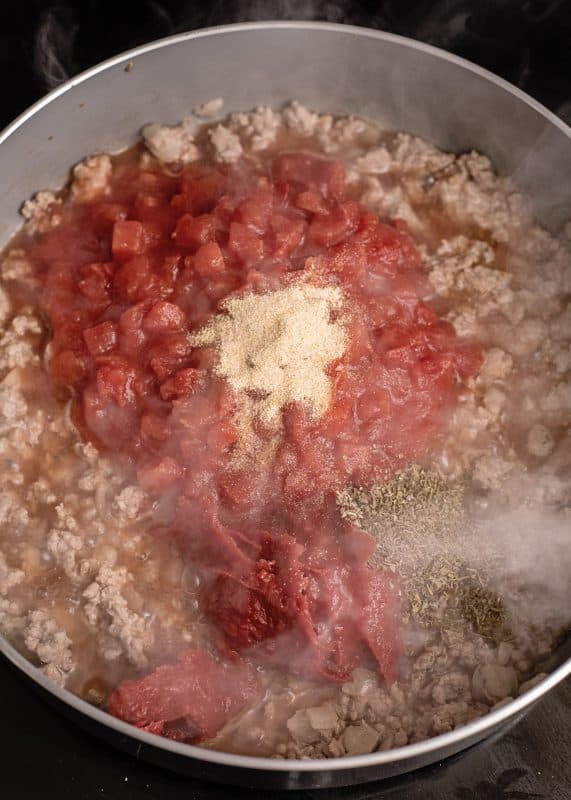Add in water, tomato paste, diced tomatoes, Italian seasoning, and garlic powder.