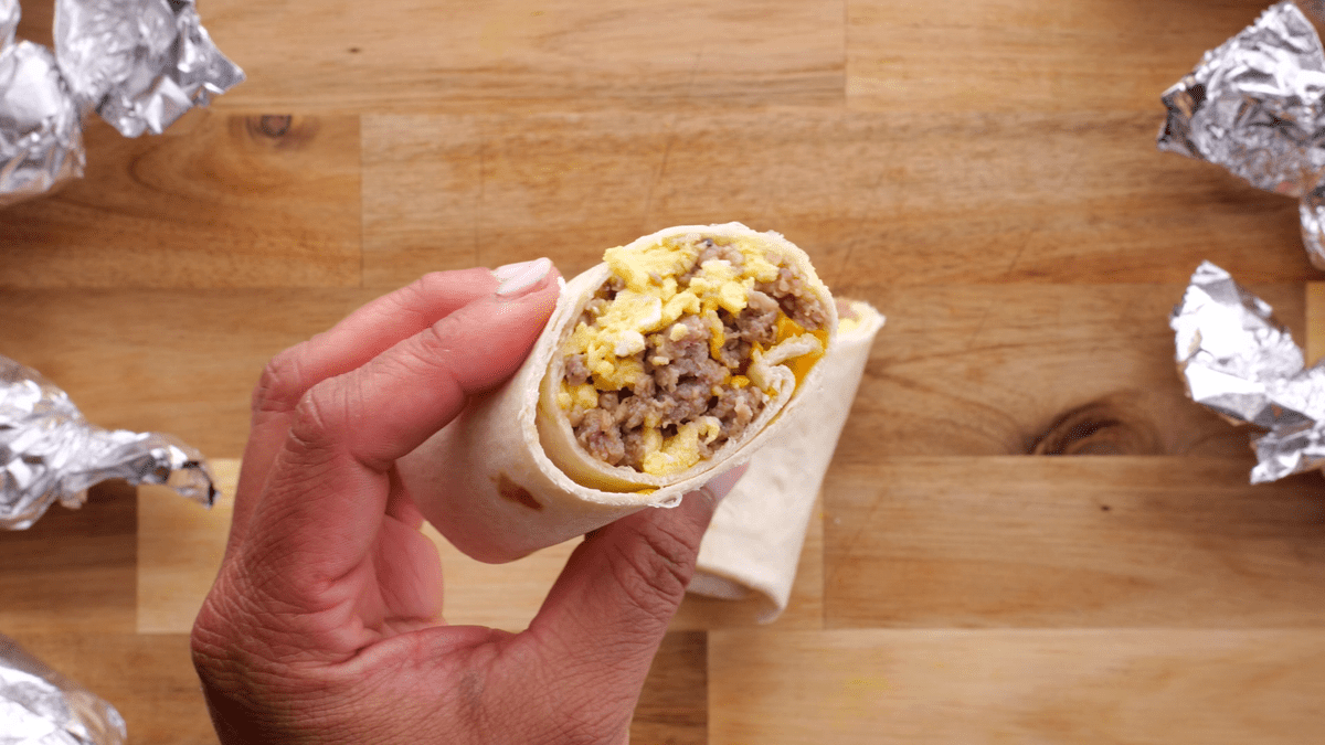 Up close view of cut in half breakfast burrito.