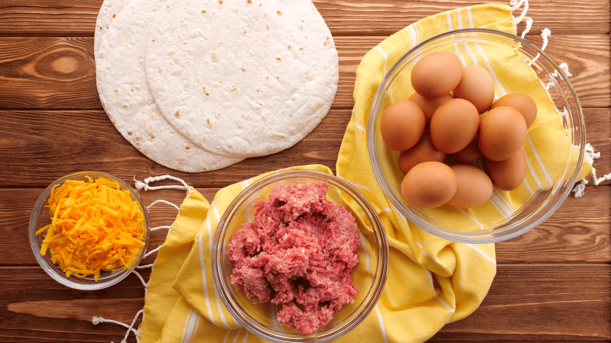 Recipe ingredients for make-ahead breakfast burritos include flour tortillas, breakfast sausage, eggs, and cheese.