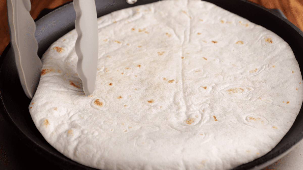 Tortillas toasting in a skillet.