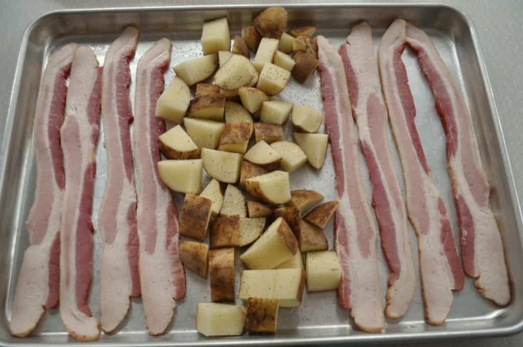 Place cut potatoes and strips of bacon on baking tray.