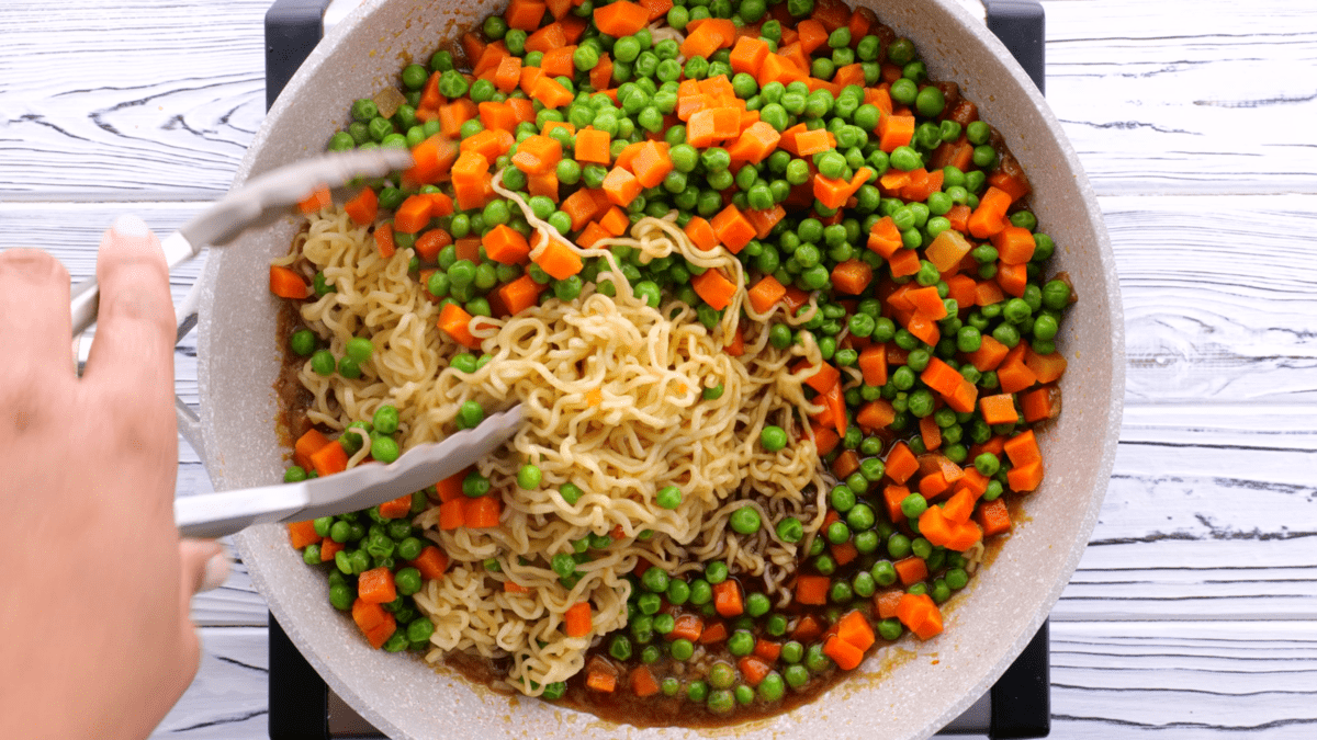 Add noodles and veggies to sauce in skillet.