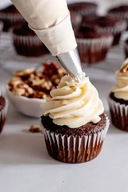 Icing Rolo cupcakes with brown butter frosting.