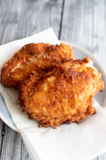 Fried chicken on paper towel-lined plate.