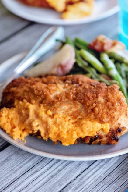 Plate of fried chicken cordon bleu with sides.