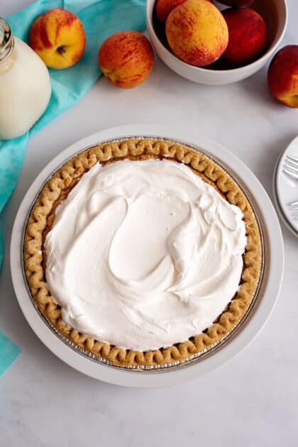 Peaches and cream pie topped with whipped cream.