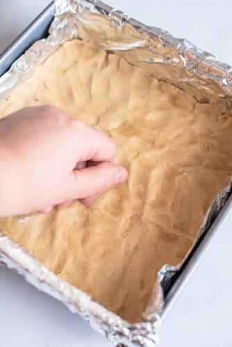 Placing cookie dough on bottom of pan