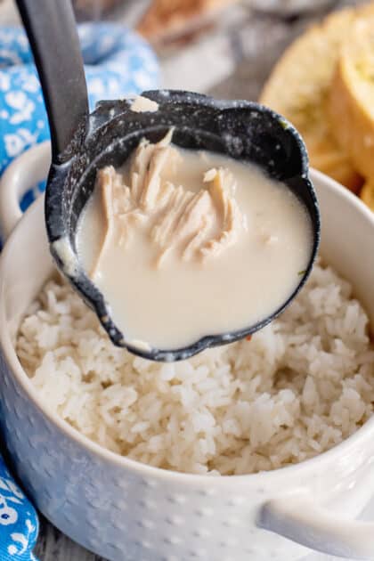 Ladle soup over rice in bowl.