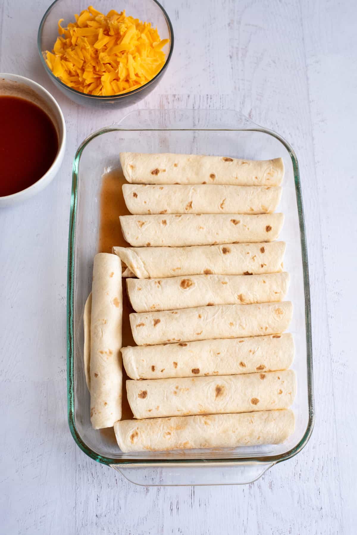 Rolled-up tortillas in baking dish.