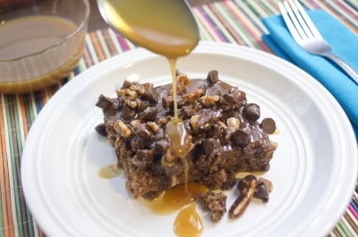Drizzling slice of Texas turtle sheet cake with caramel sauce.
