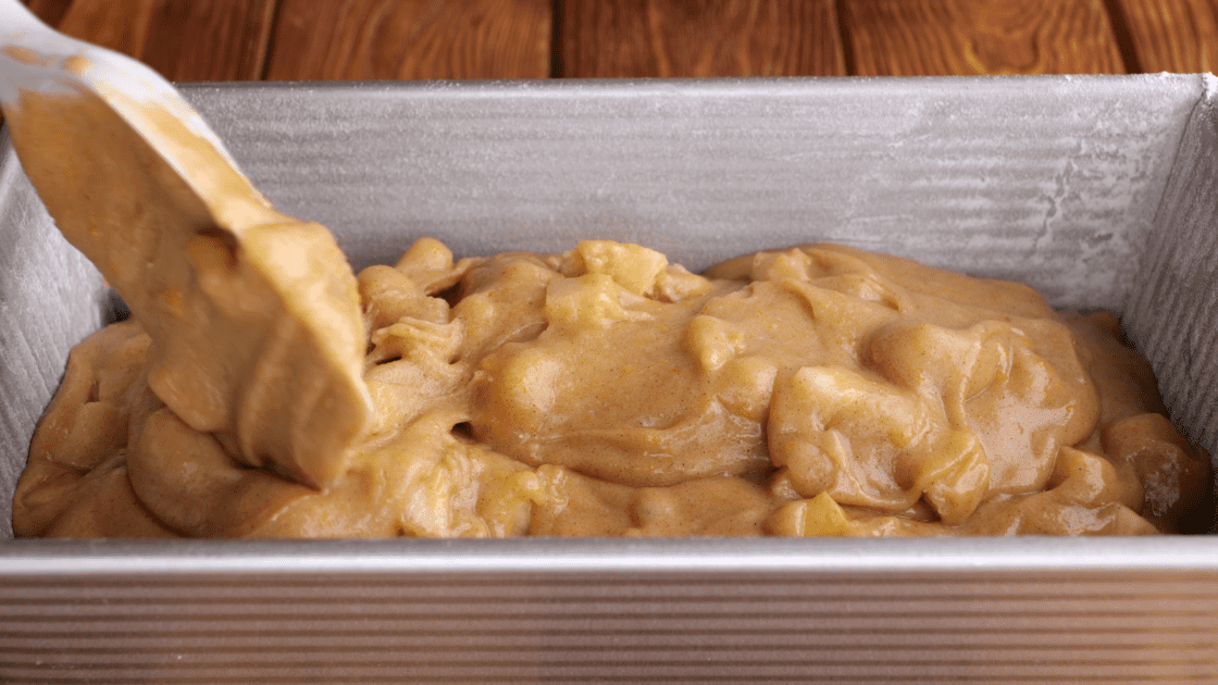 Pour apple bread batter into greased loaf pan.