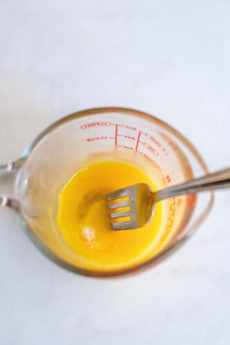 Beat egg yolks with fork.