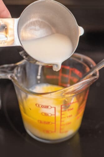 Add small amount of custard to egg yolks and stir well.