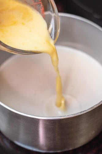 Pour egg yolk mixture into custard on stove.