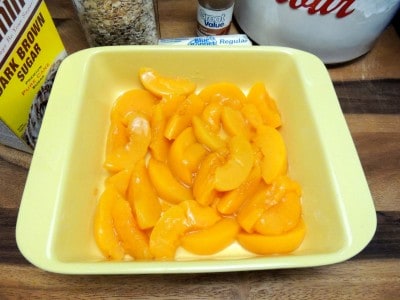 Place drained peaches in baking dish.