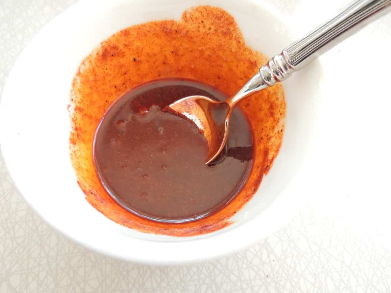 Spicy sauce for chicken paprika in a white mixing bowl.