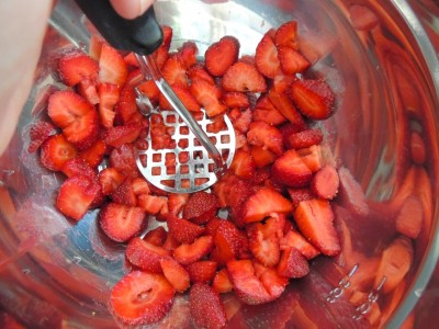 Mash strawberries with a potato masher.