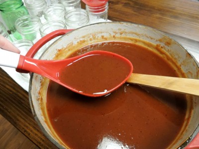 Canning ladle filled with bbq sauce.
