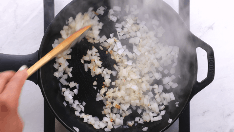 Chopping onions browning in skillet.