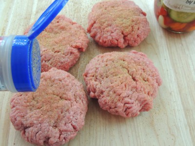 uncooked burger patties seasoned with salt