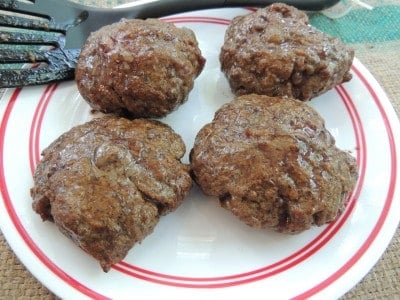 four smoked burgers on a plate