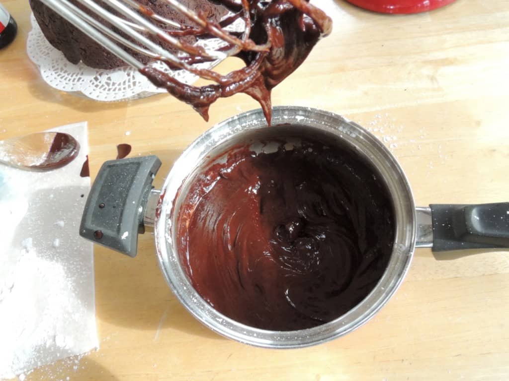 Chocolate icing ready to drizzle over cake.