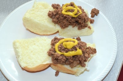 2 open loose meat sandwiches with mustard.