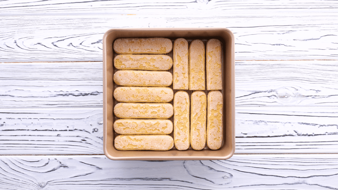 Place ladyfingers in the bottom of a baking dish.
