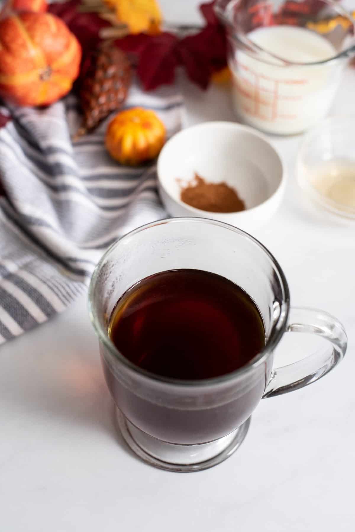 Brewed cup of coffee in a glass mug.