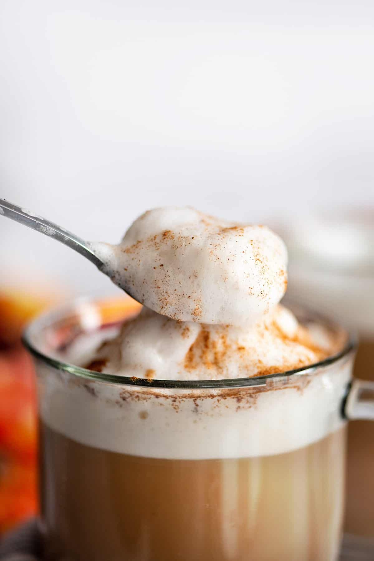 Spoonful of froth on top of sugar-free pumpkin spice latte.