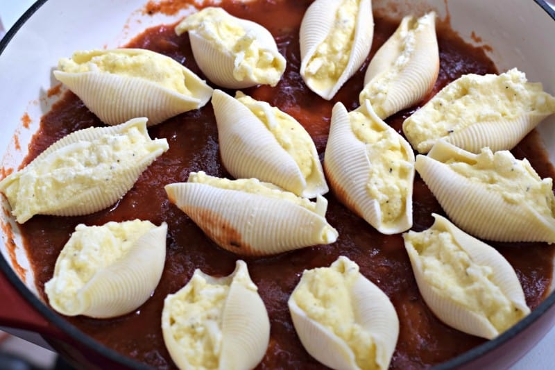 Bake stuffed shells in marinara sauce.