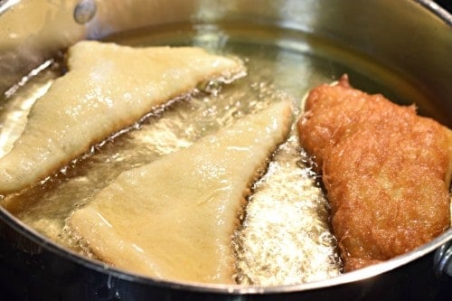 Cook sopapillas in oil until golden brown on both sides.