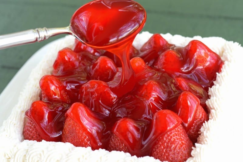 Spoon glaze over strawberries.