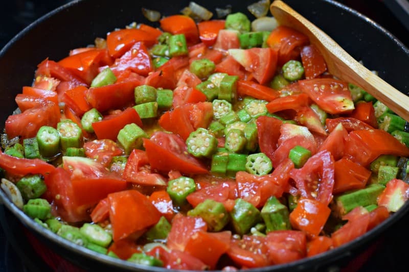 Add okra and tomatoes to skillet.