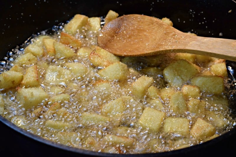 Fry potatoes in oil in skillet.