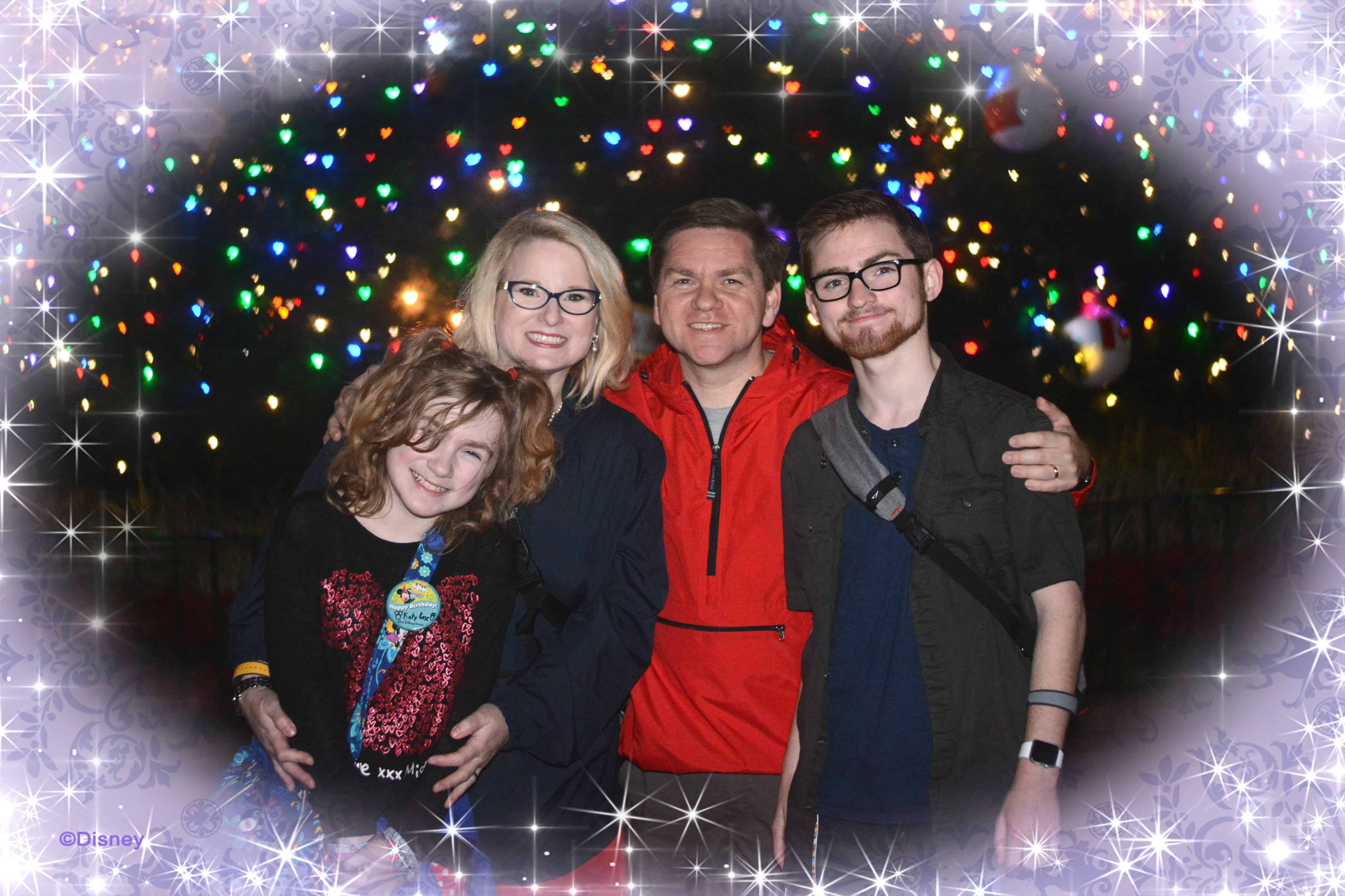 A family embracing for a photo with glitter graphic framing the photo.