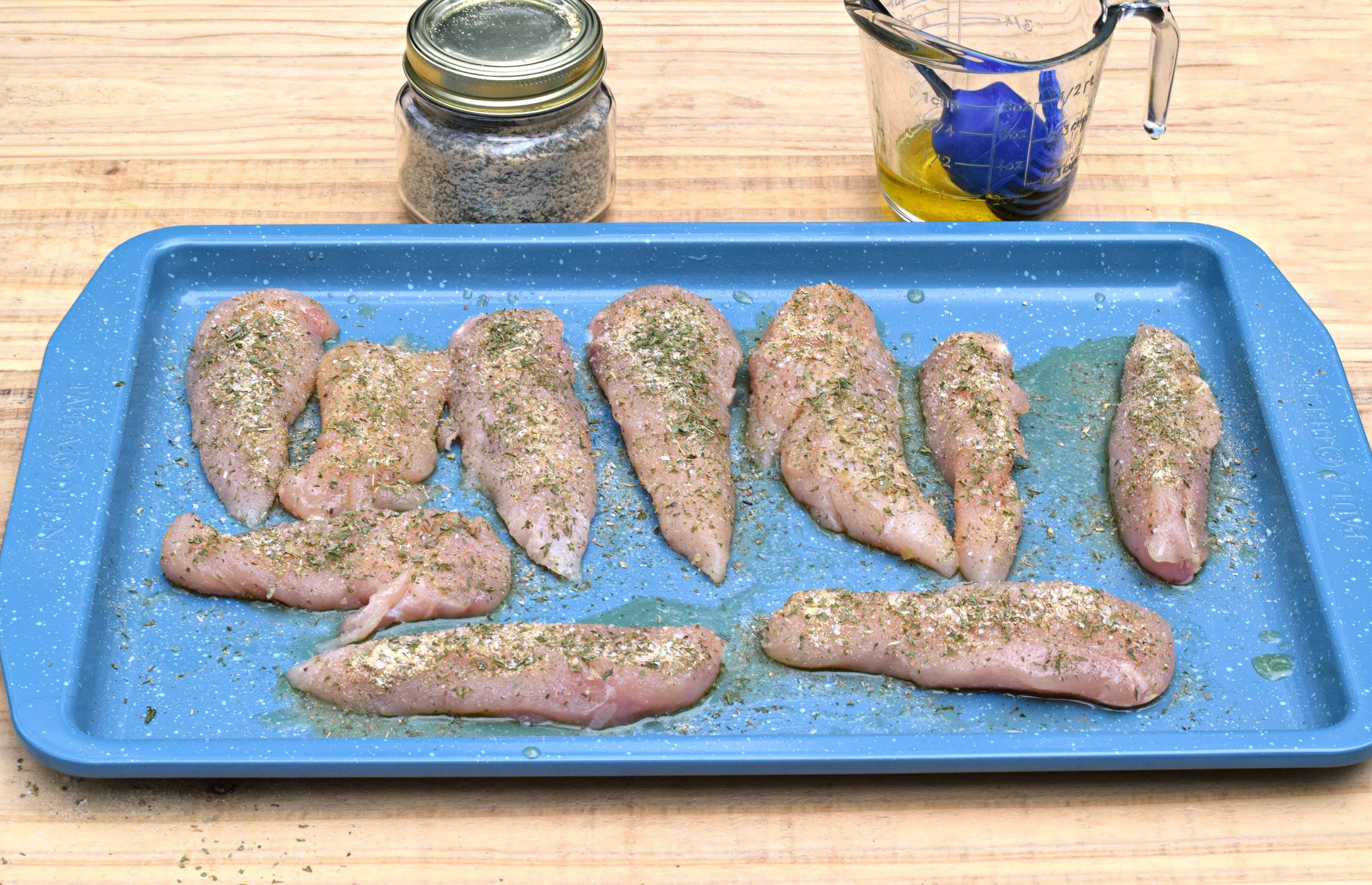 Place chicken on baking sheet, brush with oil, and cover with seasoning.
