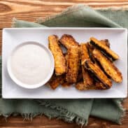 Plate of baked zucchini fries with dipping sauce.