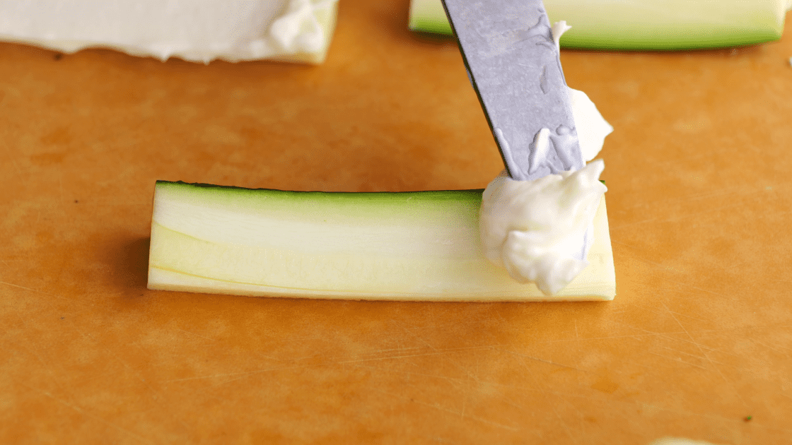 With knife, spread mayo on each side of zucchini.