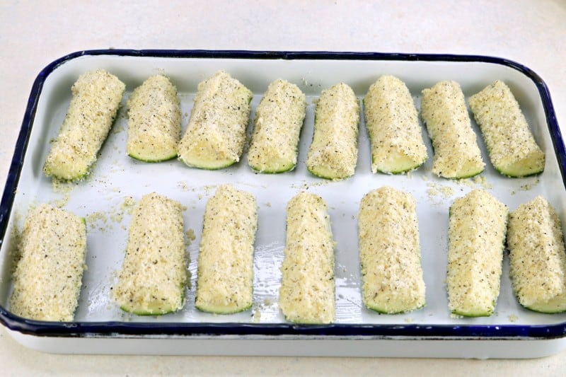 Zucchini pieces in baking dish, ready to go in oven.