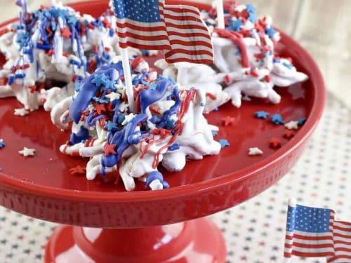 Old glory haystacks candy on a cake tray topped with patriotic sprinkles.