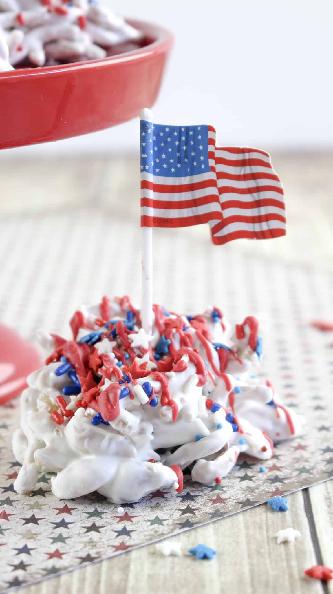 Close-up of one old glory haystack candy with sprinkles and a mini American flag.