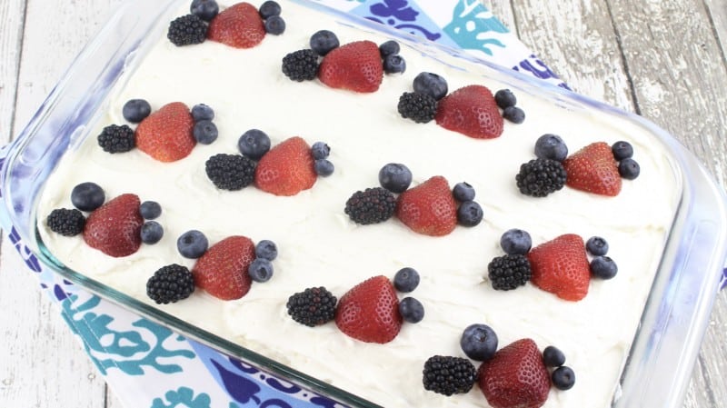 Garnish Chantilly Sheet Cake with berries before refrigerating.