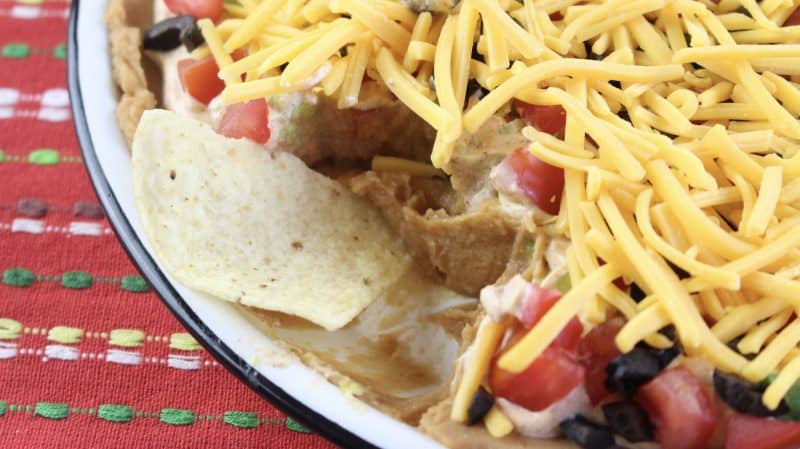 Dipping a corn chip into 7-Layer Tex Mex Dip.