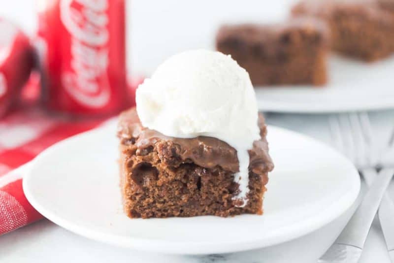 Slice of Coca-Cola Cake with a scoop of ice cream on top.