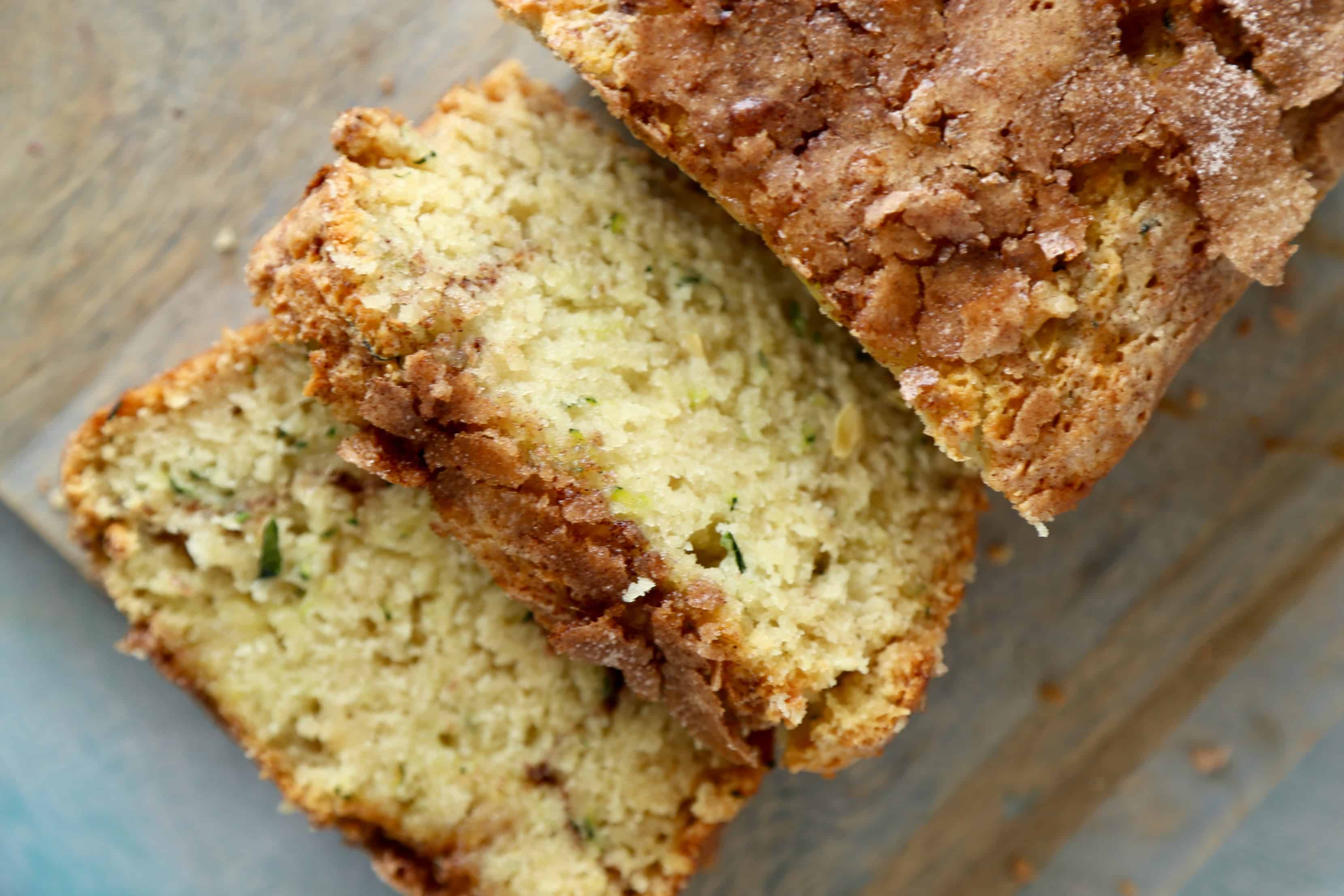 Overhead image of two slices of snickerdoodle zucchini cake falling from a loaf.