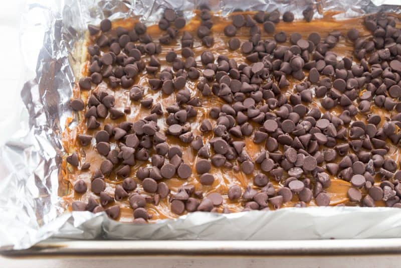 Add caramel layer then spread chocolate chips on top and melt quickly in oven.